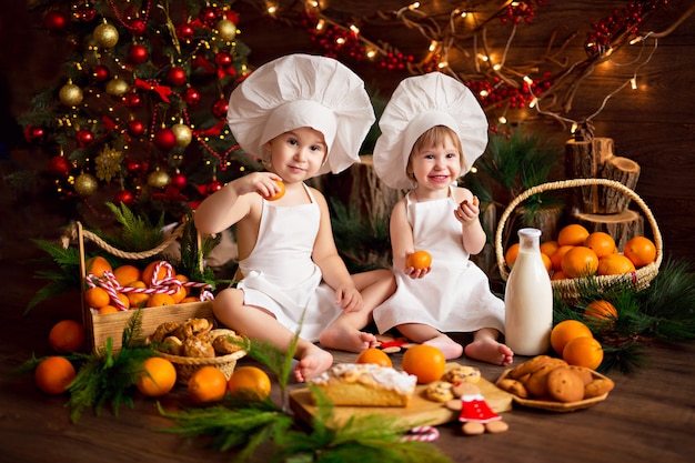 Babykoch, der lebkuchenplätzchen vorbereitet. frohe weihnachten, mandarinen, weihnachtsbaum