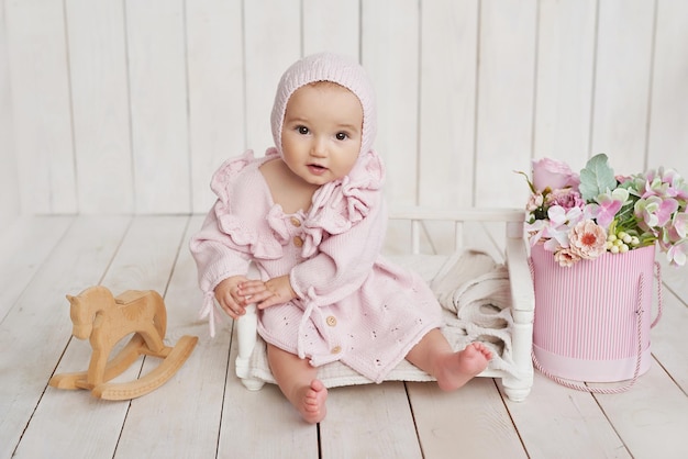 Babymädchen in Hut mit Holzspielzeug Postkarte Muttertag und Ostern Kinderschutztag Weltglückstag Lächelndes Kind