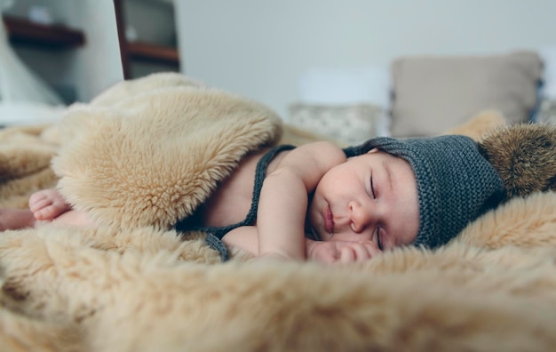 Babymädchen mit Bommelmütze schläft