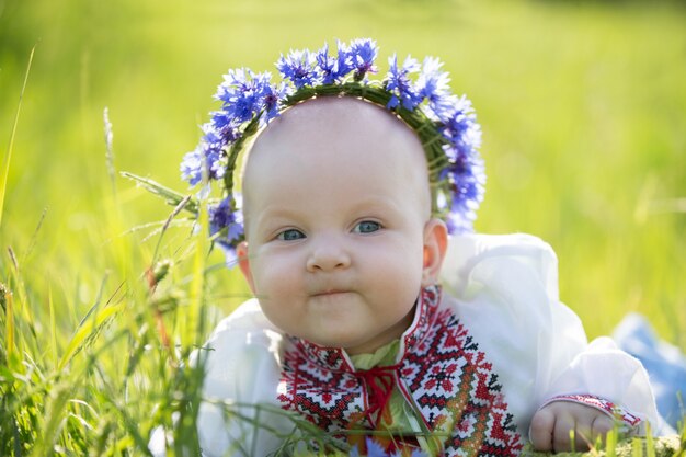 Babymädchen mit Kornblumen in bestickt. Symbol von Weißrussland