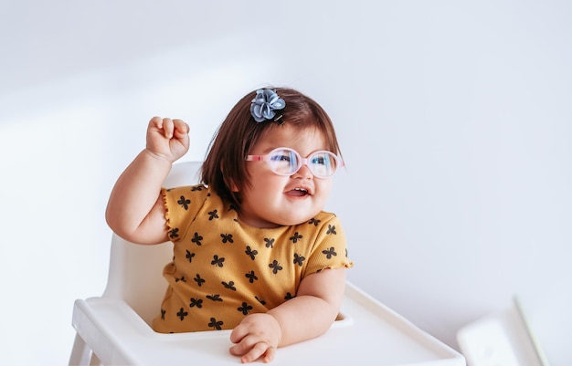 Babymädchen mit schlechtem Sehvermögen. Kind mit Brille. Nettes Mädchen mit Brille, das glücklich spielt