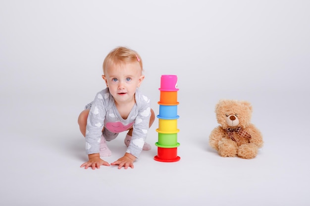 Babymädchen spielen mit Lernspielzeug auf weißem Hintergrund