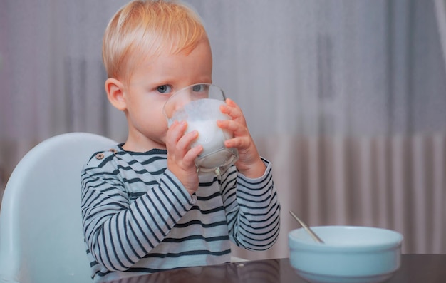 Babynahrung gesund essen Kleinkind mit Snack gesunde Ernährung trinken Milch Kind halten Glas mil