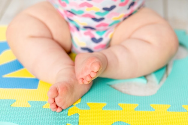 Babys Füße auf der hellen Spielmatte