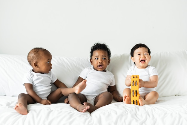 Babys sitzen auf dem Bett