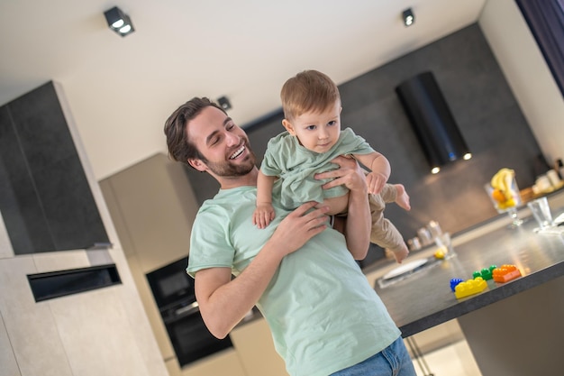 Babysitting. Der junge Vater verbringt Zeit mit seinem süßen Jungen und sieht glücklich aus