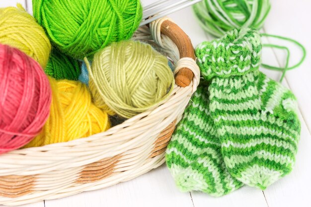 Babystricksocken auf weißem Holzhintergrund