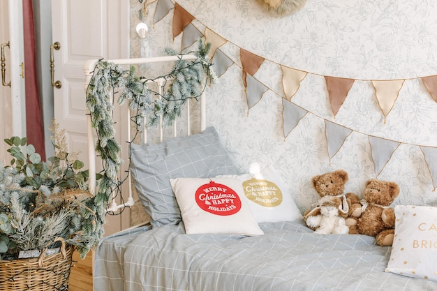 Babyzimmer weihnachtlich geschmückt. Modernes Interieur für Kinder. Vintage Babybett mit Kuscheltieren und Kissen