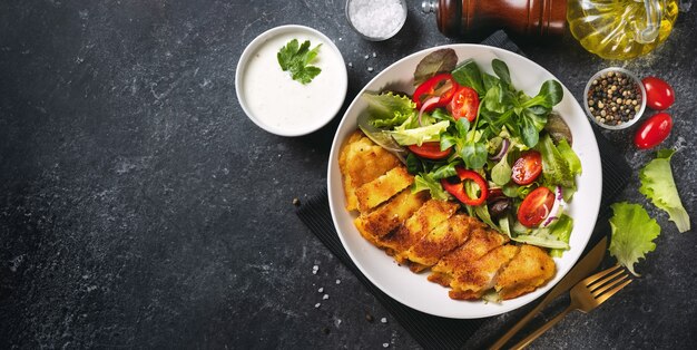 Bacalao empanizado crujiente con ensalada en un plato