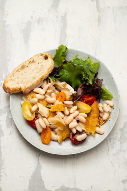 Bacalao frito con alubias blancas en el plato