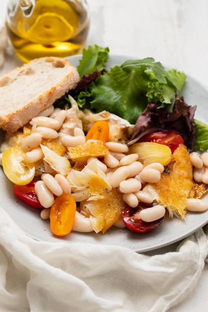 Bacalao frito con alubias blancas en el plato