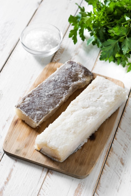 Bacalao seco salado en mesa de madera blanca Comida típica de Pascua