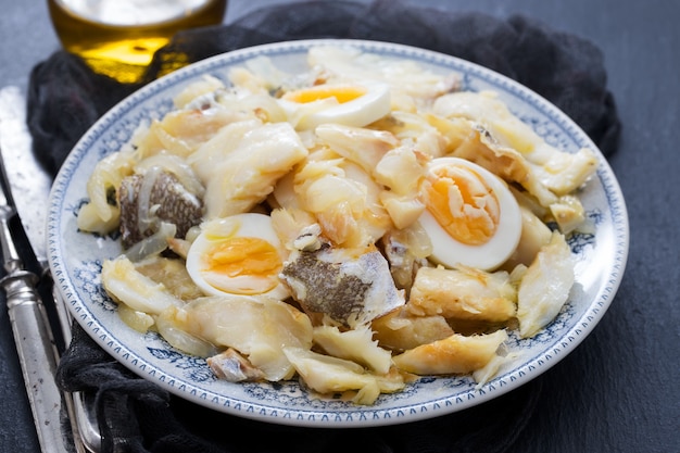 Bacalhau com cebola, ovos e azeite no prato