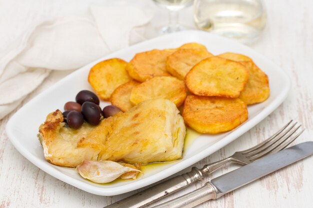 Bacalhau frito com batata no prato branco