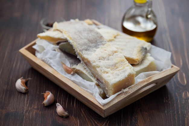 Foto bacalhau salgado seco na placa de madeira