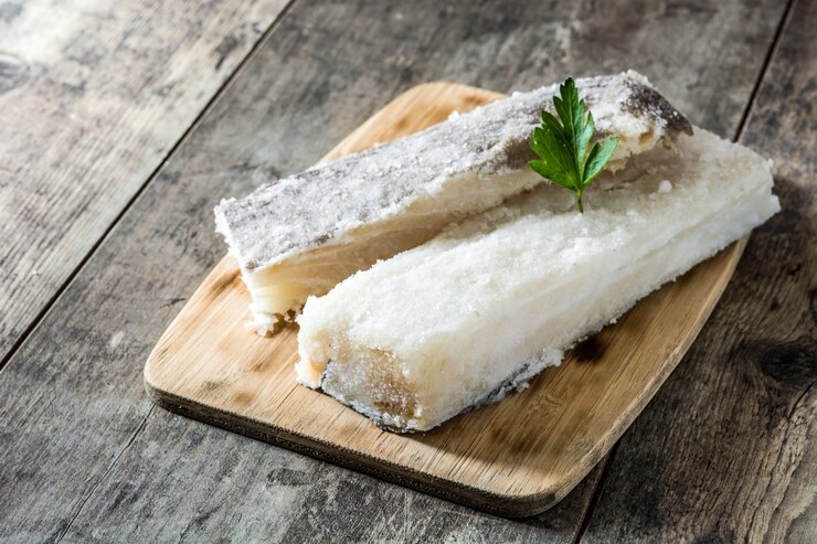 Bacalhau seco salgado na mesa de madeira branca Comida típica da Páscoa