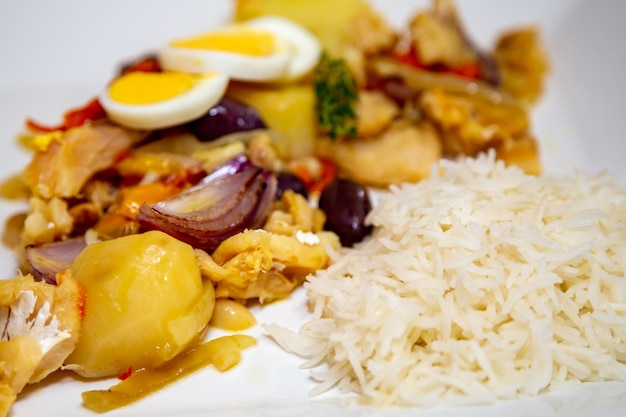 Bacalhoada tradicional portuguesa com batatas cebolas e azeite guarnecido com ervas frescas