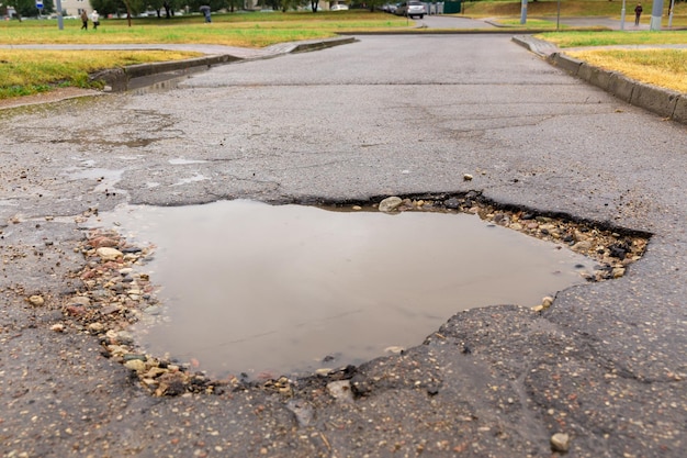 Foto un bache lleno de agua en la carretera