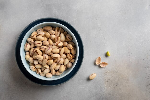 Bacia com pistache em uma parede de pedra cinza. dieta alimentar saudável