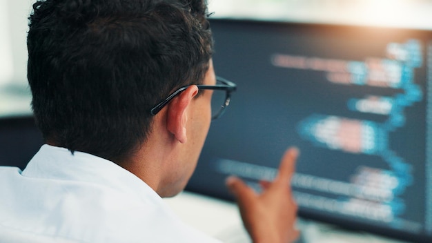Back computer screen and man in office coding research and it support with cyber security update Person programmer and employee in workplace pc and building software with developer or web design