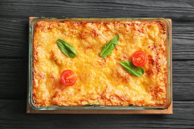 Backblech mit Spinatlasagne auf Holztisch