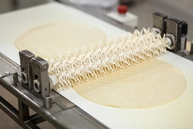 Foto backen des pizzabodens in der fabrik. schnitte beim test auf dem förderband