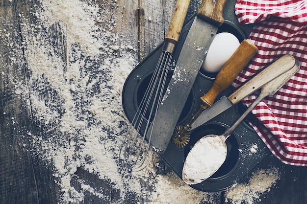 Backen Konzept Küche Kochen Besteck Zubehör für Backen auf Holzuntergrund mit Mehl. Draufsicht. Kochprozess. Niemand.