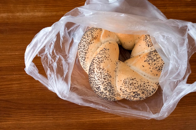 Backen. Rollen Sie mit Mohn in einer Plastiktüte auf einem Holztisch