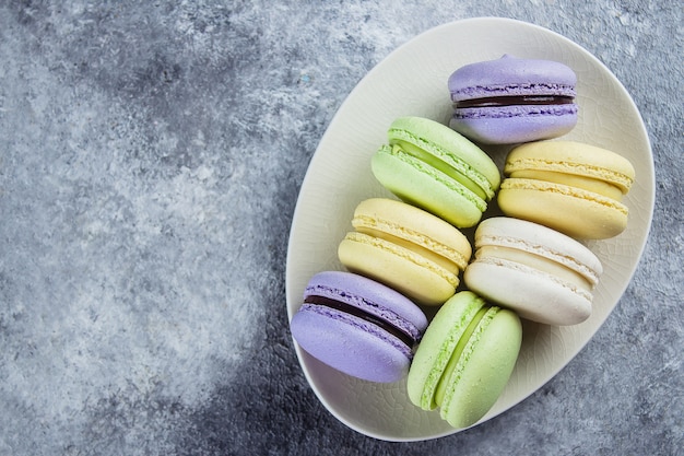 Backen Sie macaron oder Makrone auf Platte auf Hintergrund von oben zusammen