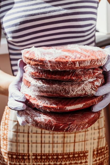 Backen Sie rotes Samtrezept zusammen Kekskuchen, Beschaffenheit, Makrorot backt in den Händen des Patissiers zusammen