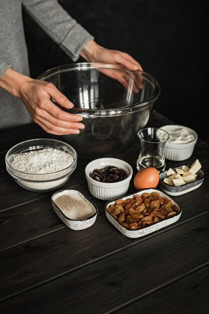 Backen von süßem Hüttenkäse-Zopfbrot mit Rosinen und Marmelade. Zutaten auf einem Holztisch. Lifestyle-Bild.