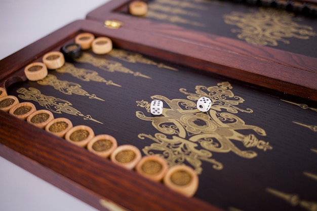 backgammon en una caja de madera huesos en la mesa blanca