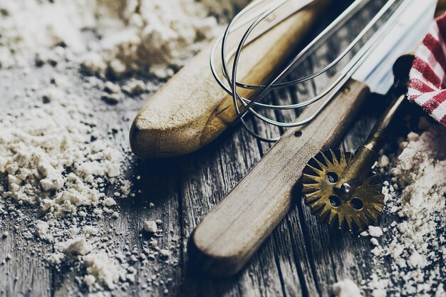 Foto backkonzept küchen kochgeschirr zubehör zum backen auf holzgrund mit mehl closeup kochprozess