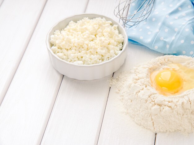 Backkuchen in rustikaler Küche - Teigrezept Zutaten Eier, Mehl, Milch, Butter, Zucker auf weißem Holzbrett Tisch von oben