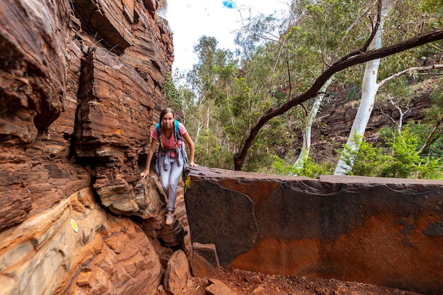 Backpacker-Mädchen, das durch eine Schlucht im Karijini-Nationalpark in Westaustralien wandert