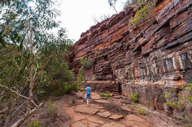 Backpacker-Mädchen, das durch eine Schlucht im Karijini-Nationalpark in Westaustralien wandert