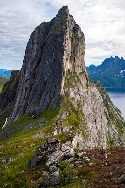 Backpacker-Mädchen wandern auf Hesten mit Blick auf Norwegens berühmten Segla-Berg, die Insel Senja. hesten