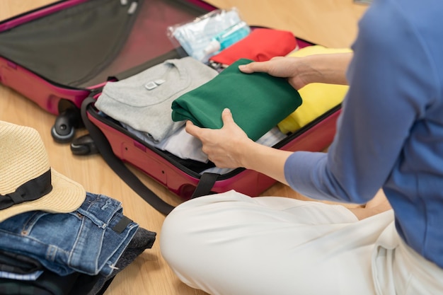 Backpacker-Reise der Reise asiatische junge Frau, die Kleidung in den Koffer des Reisegepäcks packt oder vorbereitet, Reisenotiz und Checkliste für den Urlaub zu Hause Reise von Reisenden