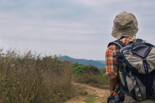 Foto backpacker steht auf dem berg gegen den himmel