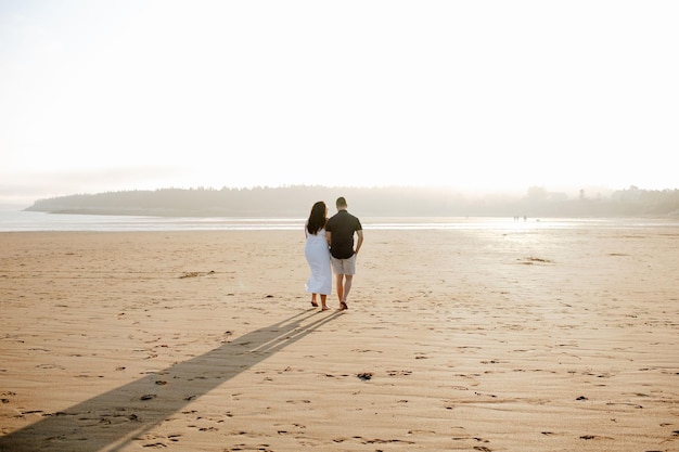 Backshot de um casal caminhando na nova praia fluvial em um dia ensolarado em New Brunswick, Canadá