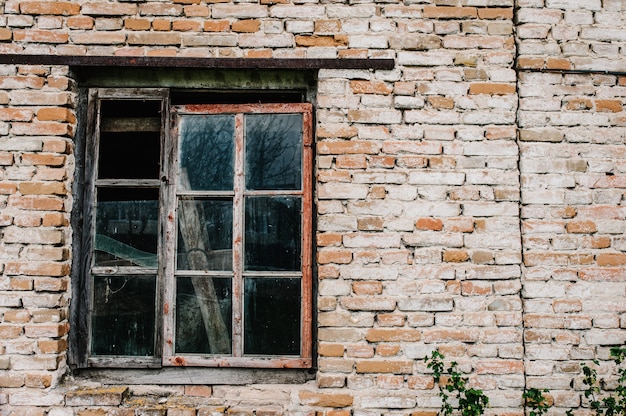 Backsteinmauer mit altem Holzfenster