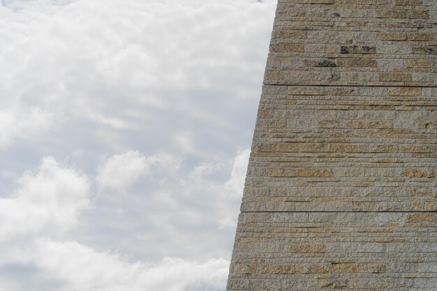 Backsteinmauer mit dem bewölkten Himmel im Hintergrund