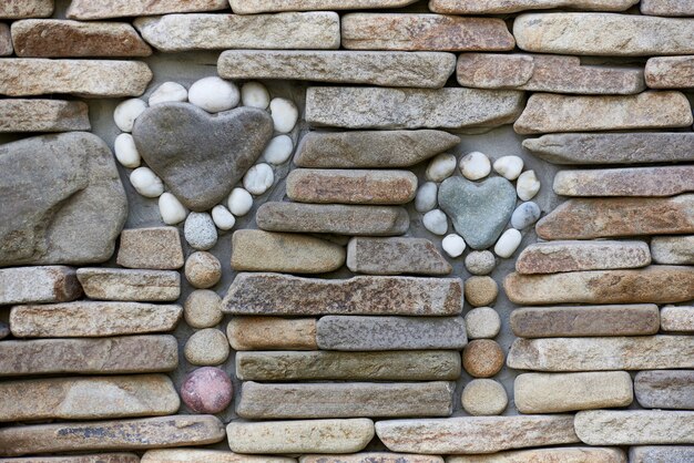 Backsteinmauer mit einer Zahl von gerundeten Steinen.