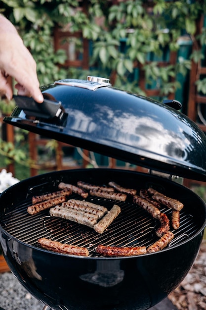 Backyard BBQ Nahaufnahme des Grillens von Fleischwürsten auf dem Grill Man bereitet schmackhafte Würste zu