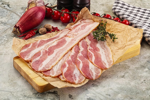 Bacon de cerdo en rodajas sobre el tablero