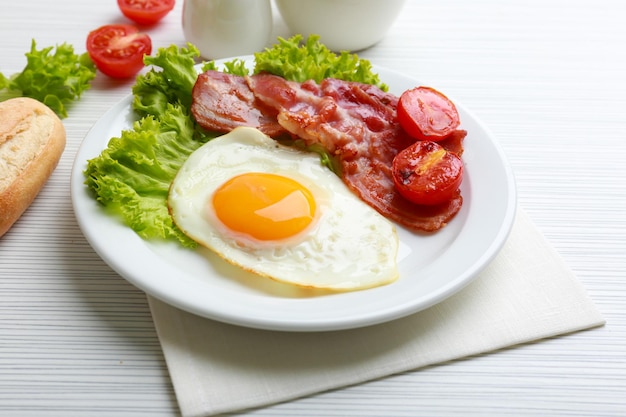 Bacon e ovos em fundo de mesa de madeira colorida