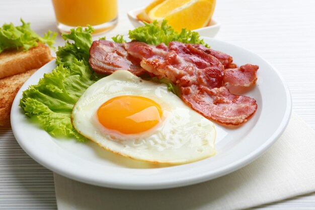 Bacon e ovos no fundo da mesa de madeira de cor