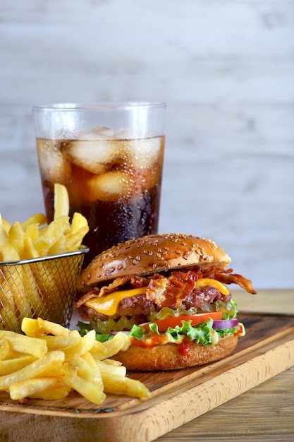 bacon e queijo Hambúrguer com batatas fritas e um copo de coca-cola