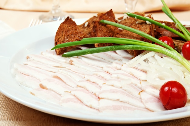 Bacon fatiado com cebola e tostas de pão em um prato de restaurante