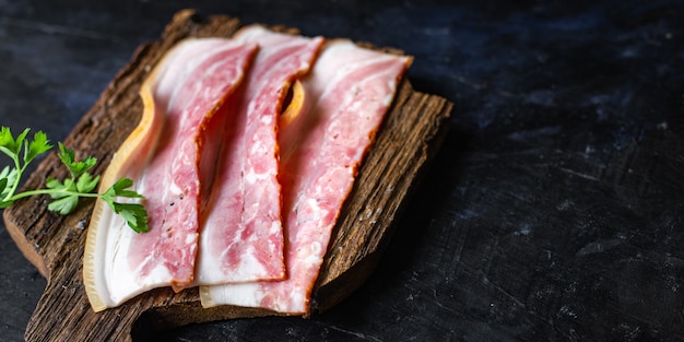 Bacon fresco, fatia fina de carne gordurosa, pedaço de banha na mesa refeição